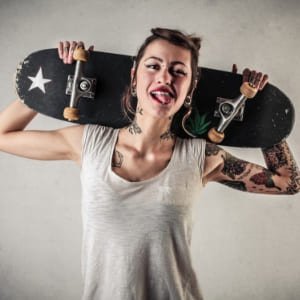 Chica skater con una tabla de skateboard a la espalda
